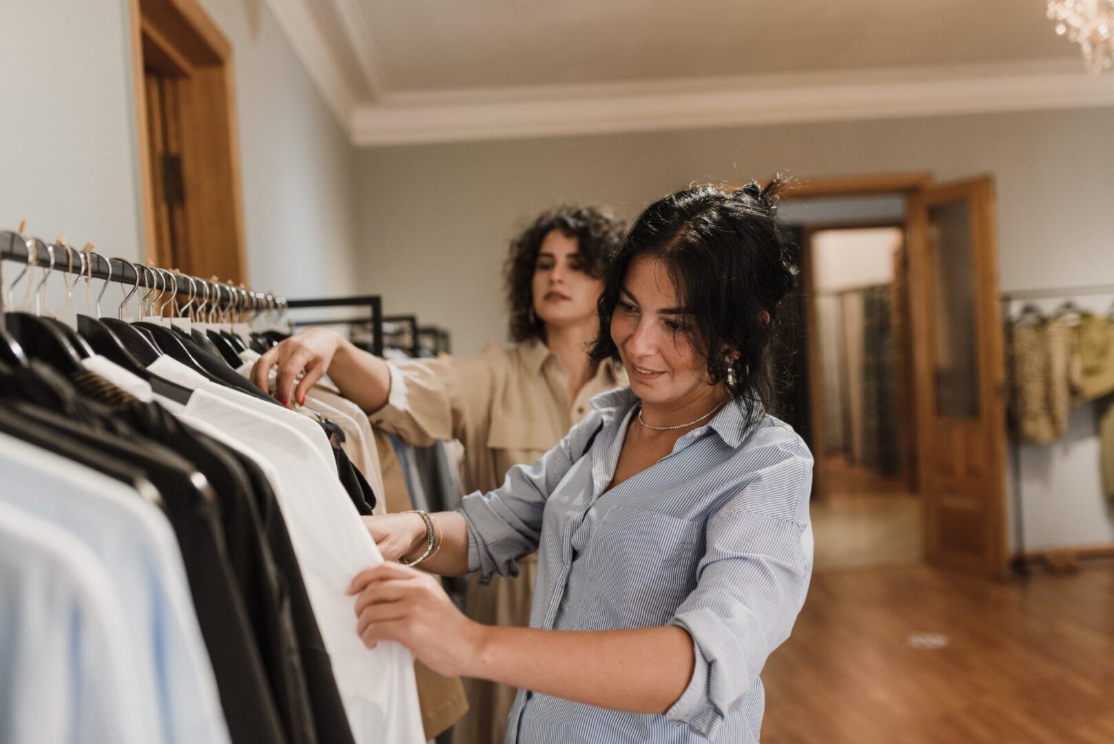 Two women looking at clothes in a clothing store.