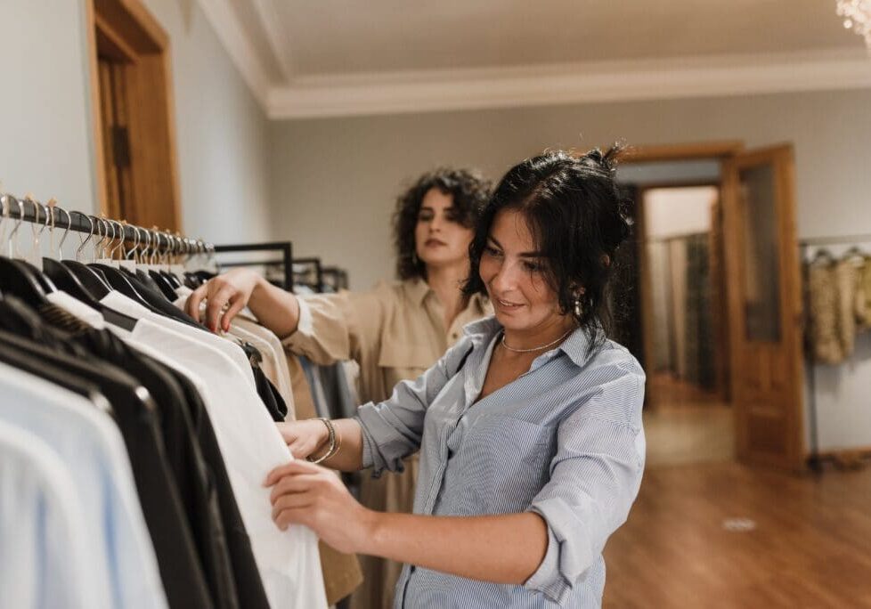 Two women looking at clothes in a clothing store.